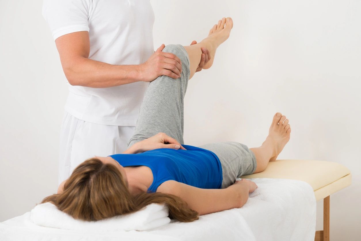 A woman is getting her legs examined by an osteopath.