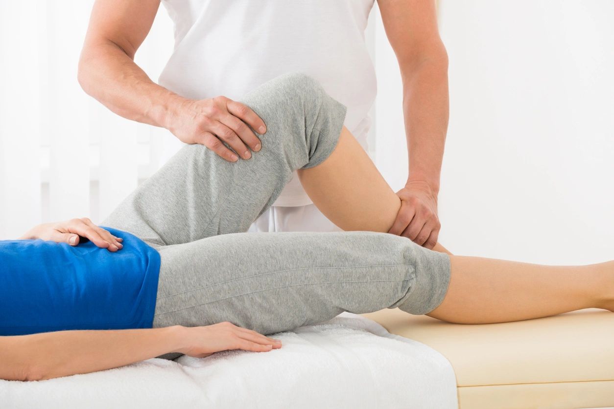 A person is getting their leg examined by an osteopath.